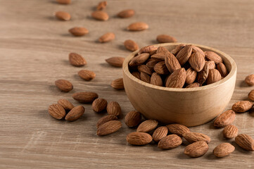 Almonds  in wooden bowl on wooden table background.