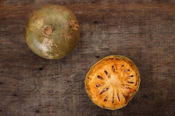 Southeast Asa wood apple bael fruit Limonia acidissima hard shell half inside flesh made juice drink ingredients