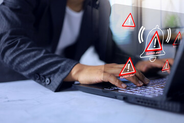 System alert concept with businessman working on laptop screen and receiving software alerts about cyber intrusion or attempted ransomware attack.