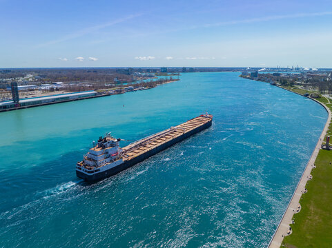 Bulk carrier sailed on St. Clair River aerial view. This river divided Port Huron, Michigan, USA (right) and Point Edward, Ontario, Canada (left). 