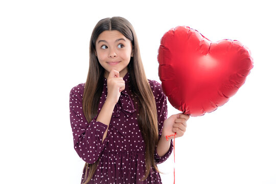 Valentines Day. Dreaming cute teen child with red heart balloon. Portrait of happy smiling teenage child girl.