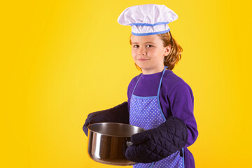 Kid cook with cooking pot. Portrait of little child in uniform of cook. Chef boy isolated on studio...