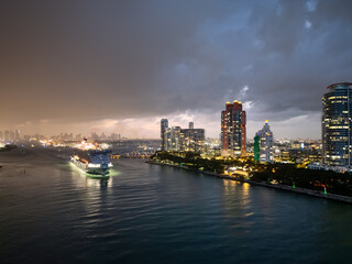 Miami skyline with ocean view. Sunset over South Florida beaches. Drone view of cityscape. Illuminated Miami skyline at night. Panoramic night of Miami waterfront. Famous landmarks of Miami Beach.