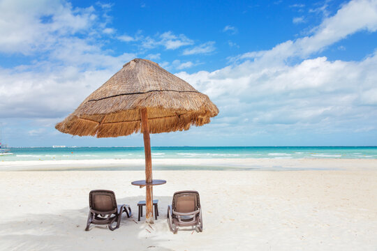 Sunshade and lounge chairs on sandy beach in the Caribbean