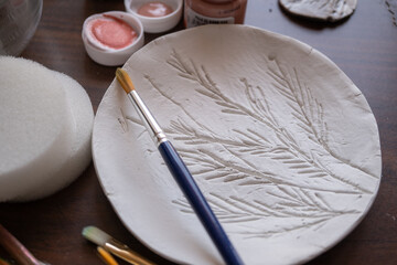 plato de arcilla blanca de secado al aire libre con textura de bajo relieve 
