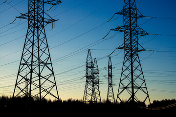 Looking up steel power pylon construction with high voltage cables against blue sky. Banner for electric energy industry with space for text