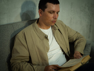 An adult man reading a book
