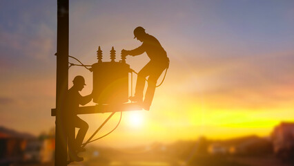 Silhouette of Electrical Engineers Working on a Power Transformer at Sunset