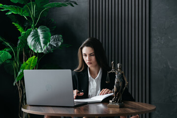 A lawyer or attorney reviews client files, interview transcripts, evidence with a laptop computer...