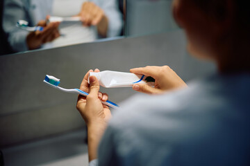 Close up of woman brushing her teeth in bathroom.