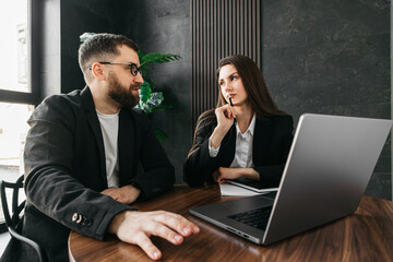  Two business team leaders man and woman working in the office at a corporate meeting at a laptop...