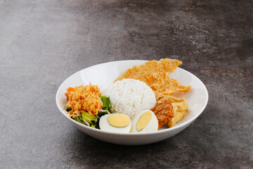 Nasi Gudangan, rice served with various vegetable with grated coconut seasoned and various side dishes. Indonesian food
