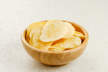 Potato Chips, served in wooden bowl on white background.
