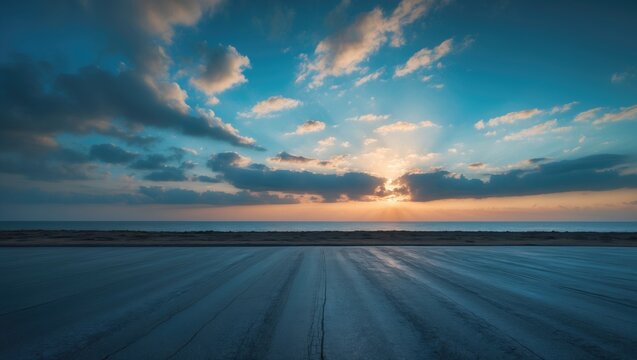 Fototapeta Natural scenery featuring an empty asphalt street and sea during sunrise