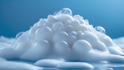 Blue background featuring white soap foam and bubbles in a macro view