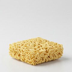 Uncooked instant ramen block in a neutral setting. A square block of uncooked instant ramen noodles is displayed on a white background.
