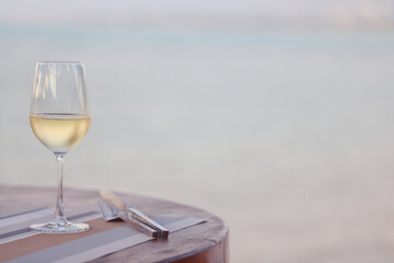 glass of cold white wine on the summer seashore by the water, relaxing by the water, a gentle background of soft color