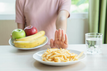 Woman on dieting for good health concept. Woman doing cross arms sign to refuse junk food or fast...
