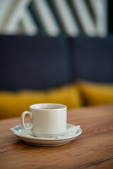 A serene moment unfolds with an elegant coffee cup resting on a wooden table, inviting relaxation