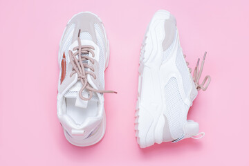 Pair of stylish sneakers on pink background close-up.