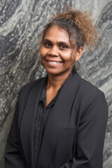 aboriginal australian business woman portrait in modern office against stone wall, with diversity theme	