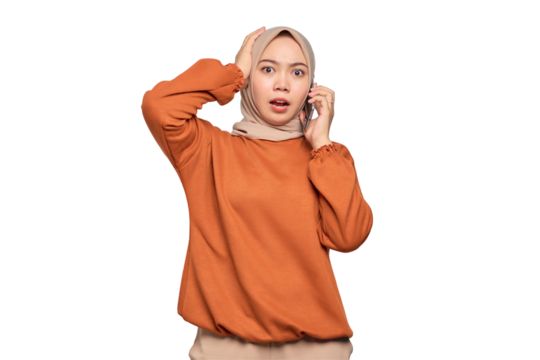 Amazed young Asian woman in orange shirt talking on mobile phone isolated on transparent background