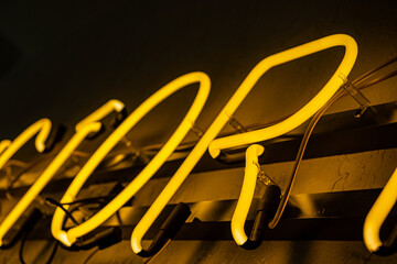 Vivid neon letters glow warmly, adding charm to a lively atmosphere during a joyful night outing