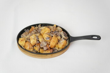 vorotka with fried potatoes and meat with mushrooms and cream sizzling pan filled with golden roasted potatoes seasoned with spices, served fresh at a Christmas market. The vibrant colors and street 