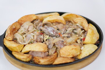 Mushrooms potatoes meat close-up. Roast with a potato, meat and mushrooms and vodka in a transparent 