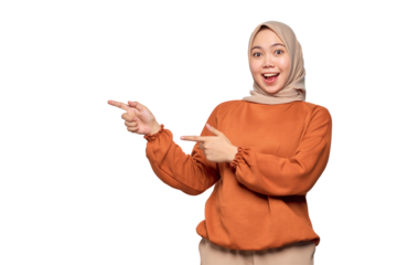 Amazed young Asian woman in orange shirt pointing fingers at copy space isolated on transparent background