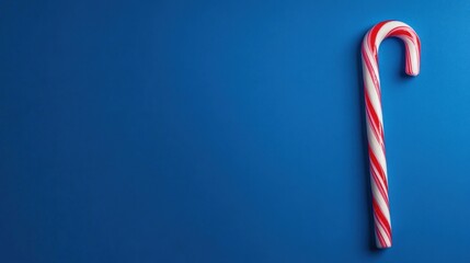 Red and white candy cane on blue background festive winter treat