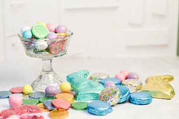 Assorted Easter candies and chocolates in glass dish and scatter