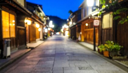 Fototapeta premium A serene, blurred street scene at night, illuminated by warm lights from traditional buildings, creating a peaceful ambiance