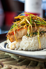 Fish filet over a bed of rice with garnish vertical