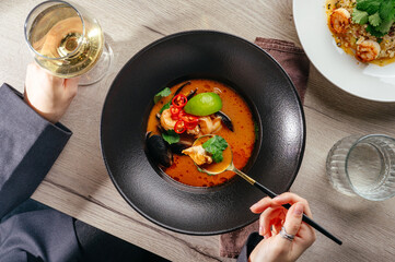 Tom Yum soup with a glass of wine in a restaurant