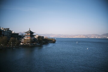 Fototapeta premium A scenic view of Dali city where urban structures meet the calm waters of Erhai Lake, located in Yunnan Province, China. 
