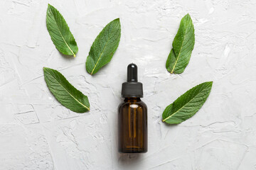 Natural Mint Essential Oil in a Glass Bottle. organic cosmetics with herbal extracts of mint on...
