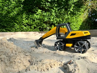 Toy children's excavator in the sandbox. Toys in the sandbox. 
