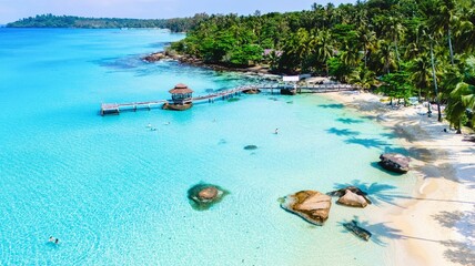 This breathtaking tropical beach features pristine turquoise waters and soft white sands, surrounded by swaying palm trees at the tropical island of Koh Kood Thailand