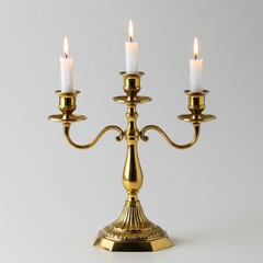 Golden candelabra with burning candles on a light surface isolated on white background