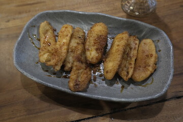 Warm and golden fried banana (pisang goreng) with brown sugar glaze served on oval plate