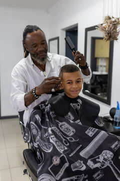 Mixed race boy having his hair cut