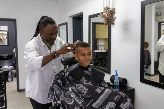 Barber cutting young boys hair