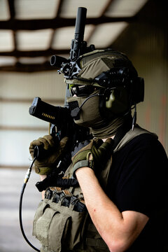 Geared-up male airsoft player with raised M4 gun