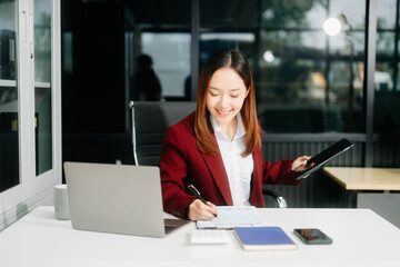 Asian business woman typing laptop and tablet Placed at the table
