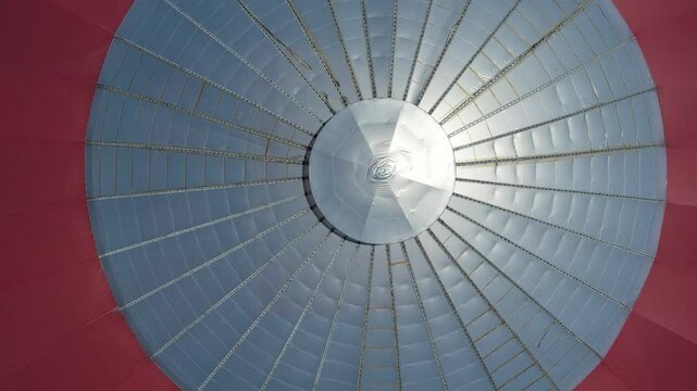 Drone footage captured view at the center of the Coliseum roof at Ibagu&eacute; Sports Park. The drone moves backward while maintaining the view, eventually reaching the entrance pathway of the Coliseum.