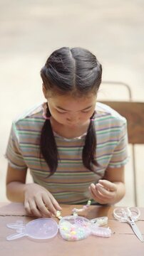 Asian girl making handmade necklace accessories