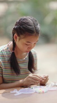Asian girl making handmade necklace accessories