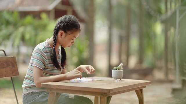 Asian girl making handmade necklace accessories