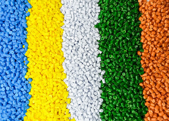 Masterbatch granules, industrial plastic manufacturing, colorful polymers arranged in rows, forming a rainbow-like shape, as a background for the design of a product catalog for an industrial plastic 